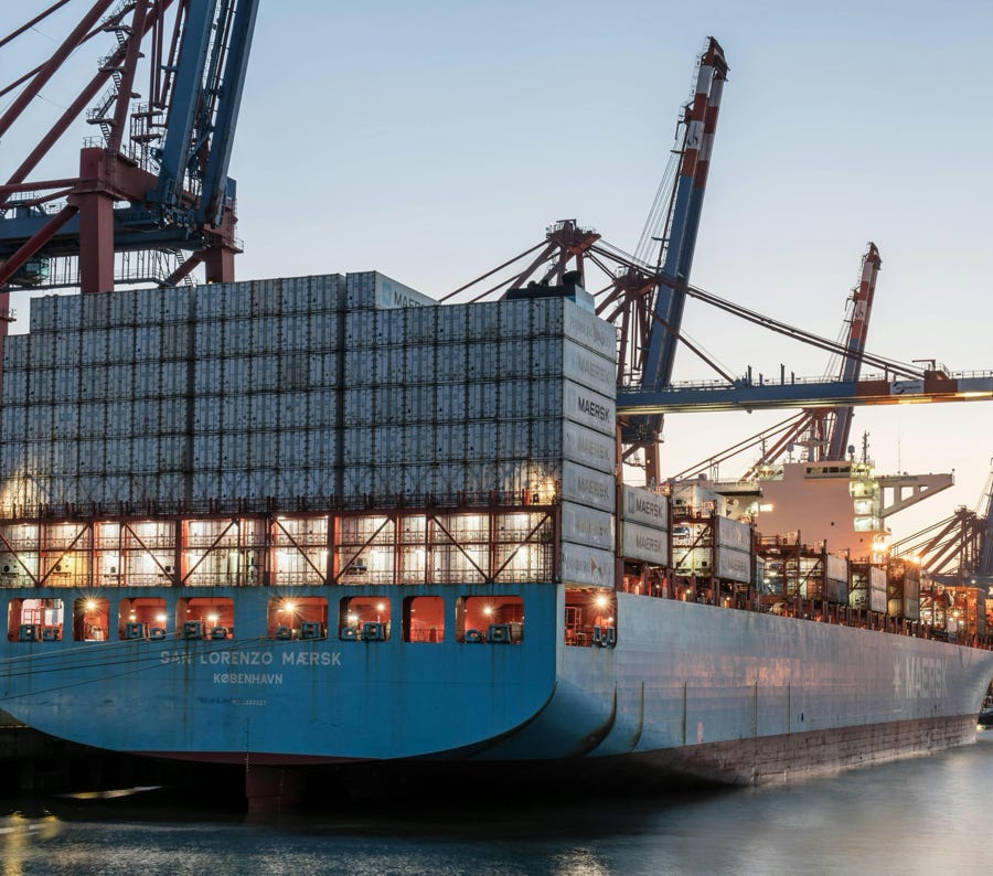 Container ship at Hamburg port during sunset, illustrating global commerce and freight transport.